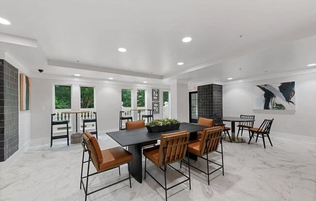 Clubhouse with a mix of long tables, chairs and windows with some cafe style seating.