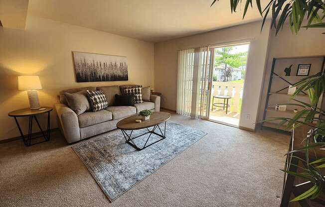 A living room with a couch, a coffee table, and a painting on the wall.