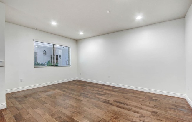 a room with a hardwood floor and white walls