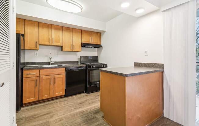 a kitchen with black appliances and wooden cabinets and a counter top