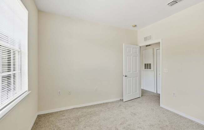 A room with a carpeted floor and a white door.