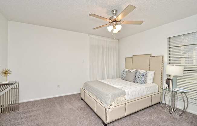 a bedroom with a bed and a ceiling fan