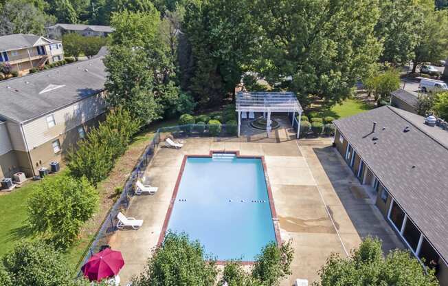 an aerial view of a swimming pool in the backyard of a house