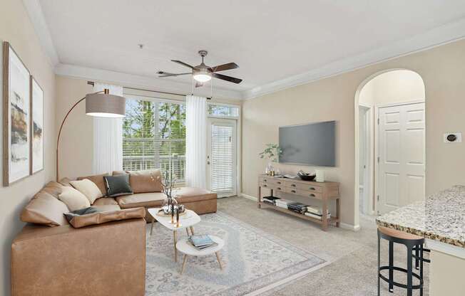 A living room with a brown couch, a coffee table, and a flat screen TV.