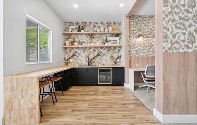 A kitchen with a wooden bar and black cabinets.