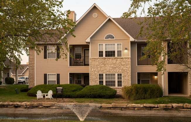 Pond with water fountain and apartments in background