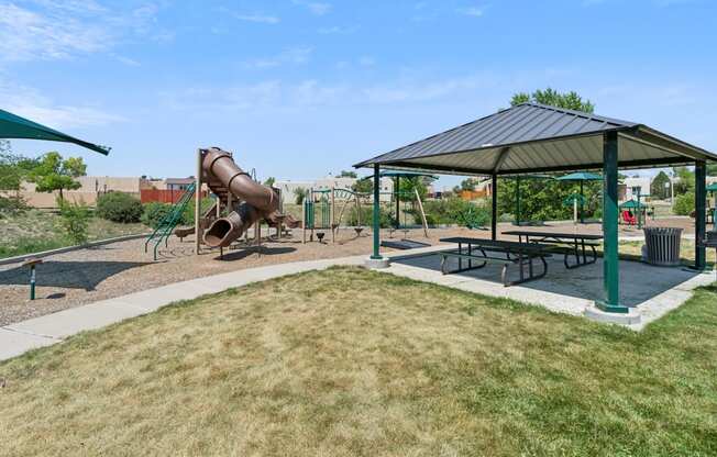 a playground with a slide and picnic table in a park