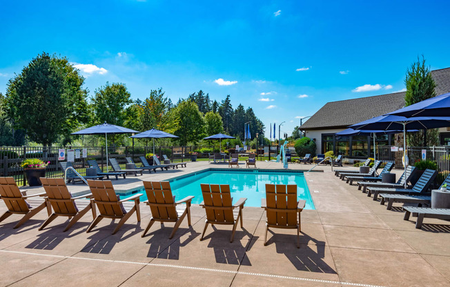 our resort style pool is filled with lounge chairs and umbrellas