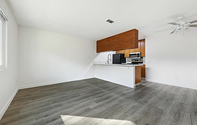 living room and kitchen with vinyl wood like flooring and stainless steel appliances