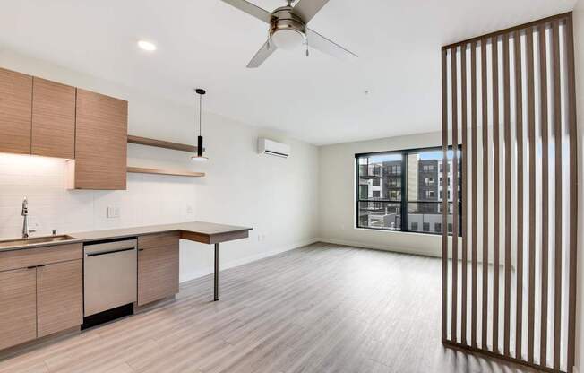 A modern kitchen with wooden cabinets and a ceiling fan.