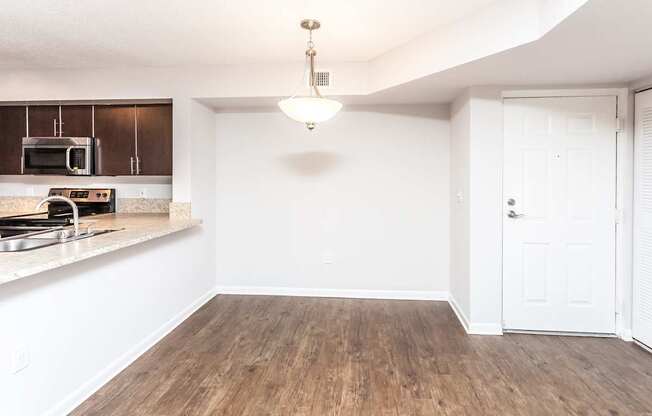 A kitchen with wooden floors and white walls.