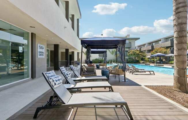 a group of lounge chairs on a patio next to a swimming pool