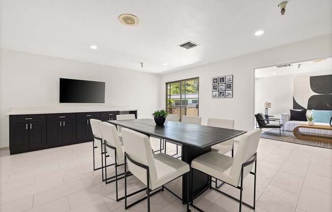 A black and white dining room with a long table and chairs.