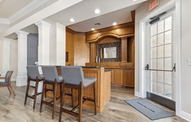 a kitchen with a bar and chairs in a house