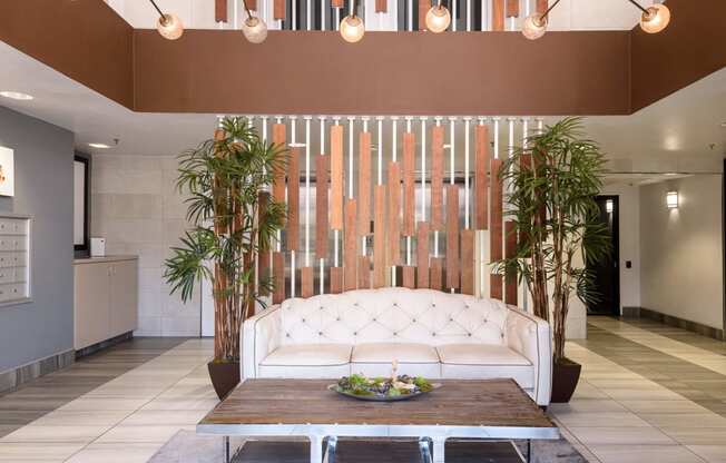 a large white couch in the middle of a room with a chandelier above it