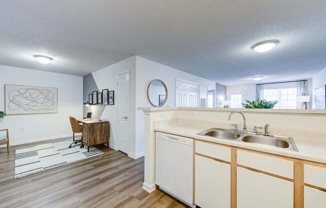 A kitchen with white cabinets and a wooden floor.