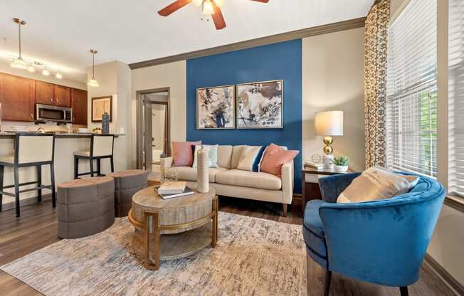 a living room with blue chairs and a geometric wallpaper