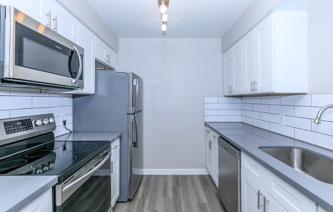 a kitchen with stainless steel appliances and white cabinets at Tides at Mesa, Mesa, AZ, 85204