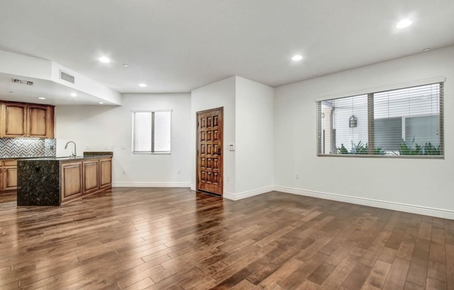 a kitchen and living room with hardwood floors and a large window