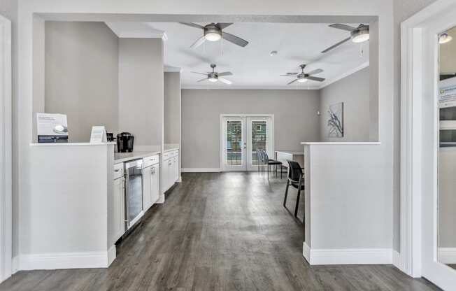 a kitchen and dining room area with white appliances and a ceiling fan