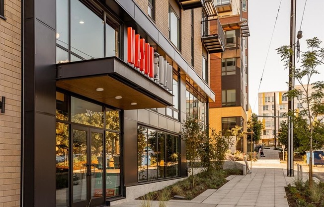 a walkway in front of a building with a large red sign on it