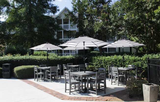 poolside patio with tables and umbrellas at Stillwater at Grandview Cove in Simpsonville, SC