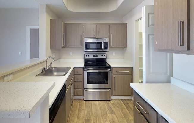 Kitchen with stainless steel microwave above matching oven, modern fixtures on cabinet fronts