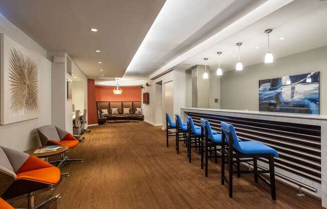 A long hallway with blue chairs on the right side.