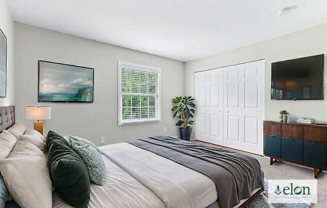 A bedroom with a large bed and a painting on the wall.