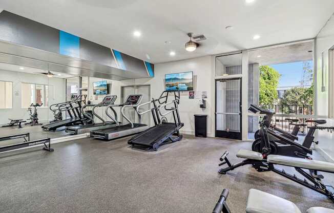 A spacious home gym with treadmills, elliptical machines, and other exercise equipment.