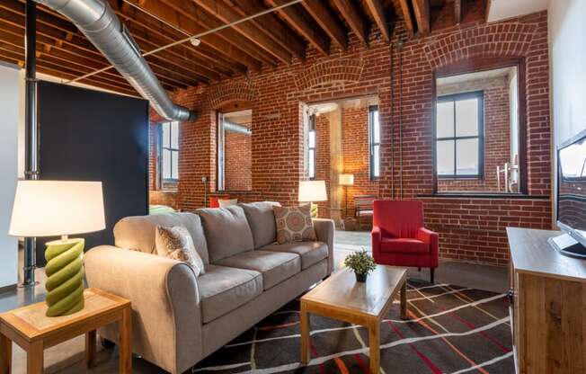 a living room with a couch in front of a brick wall