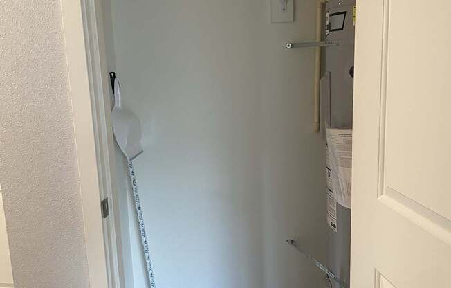 A white closet with a broom and a mop.