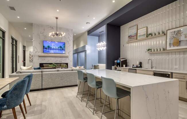 A modern kitchen with a white countertop and blue chairs.