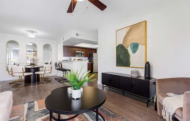 A living room with a black table and a painting on the wall.
