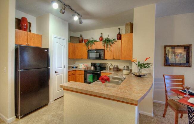 Vue Park West Kitchen with black appliances and brown wooden cabinets