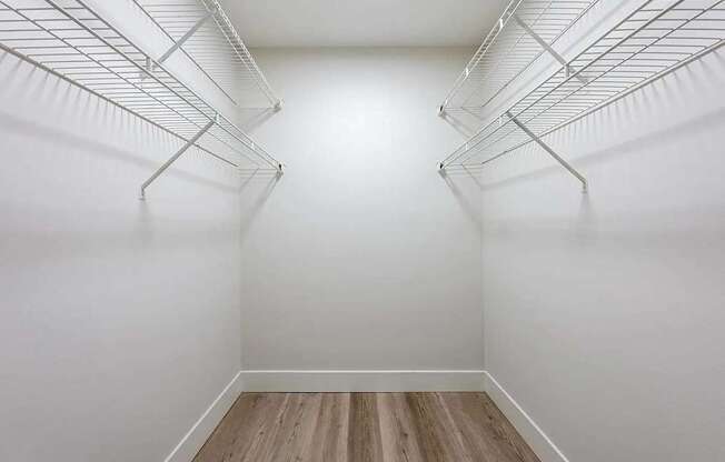 Empty white refrigerator with wood flooring.