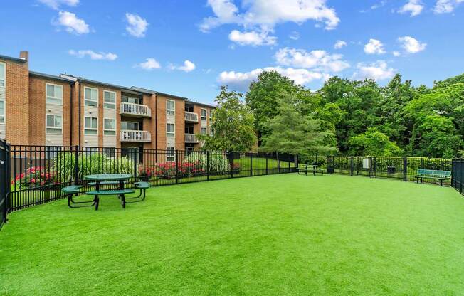 A green lawn in front of a brick building.