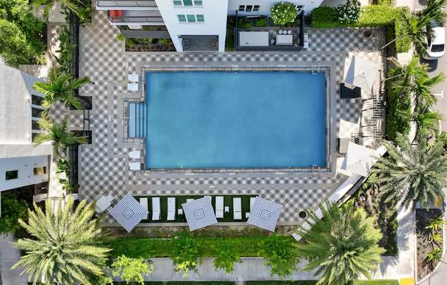 an aerial view of a swimming pool in a hotel with palm trees