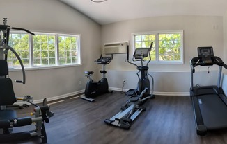 gym with exercise equipment and windows in a room with wood floors