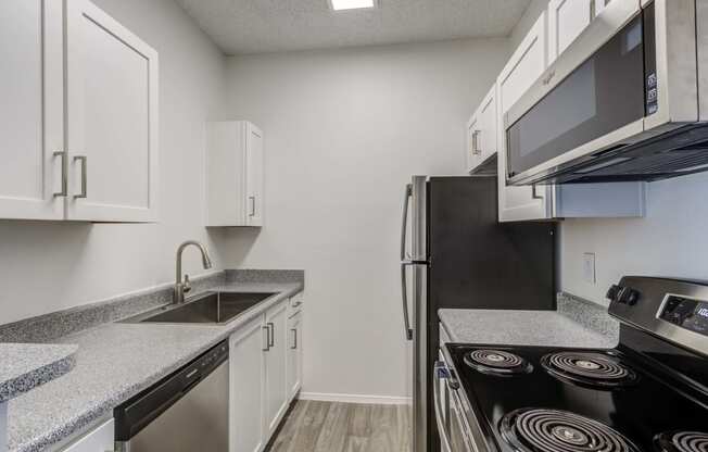 a kitchen with white cabinets and stainless steel appliances