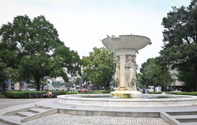 a water fountain in the middle of a park