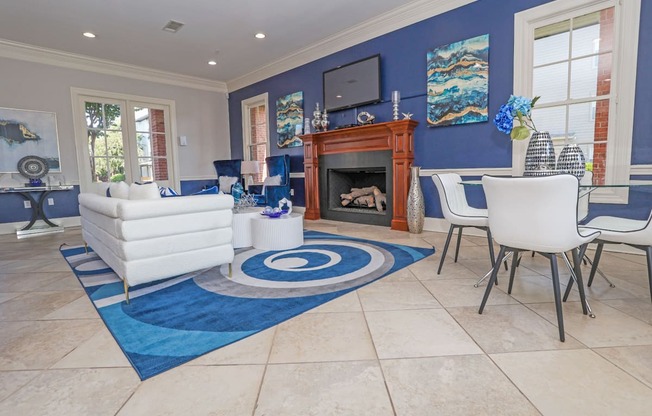 Resident lounge space with a fireplace and a blue rug at Ultris Island Park in Shreveport, LA