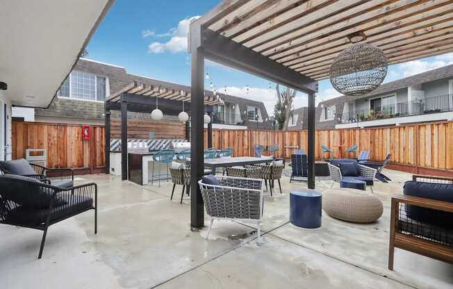 A patio with a black chair and a blue table.