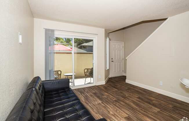 a living room with a couch and a sliding glass door to a balcony