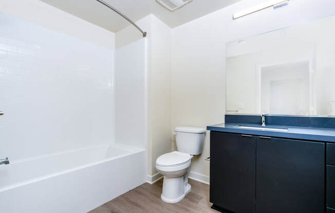 A white toilet sits next to a bathtub in a bathroom.