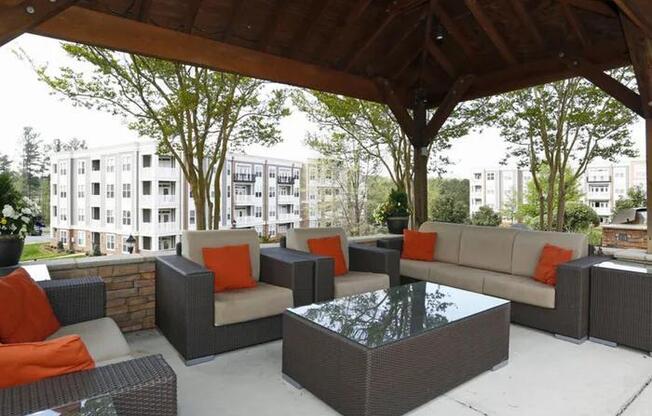 A patio with a table and chairs under a roof.