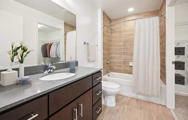 A bathroom with a sink, toilet, and shower.