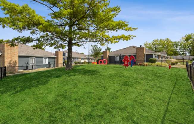 a yard with a playground and houses in the background