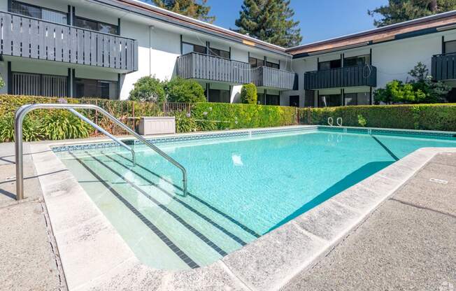 a swimming pool in front of an apartment building