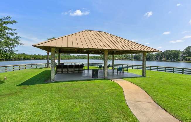a pavilion with a seating area and a lake in the background